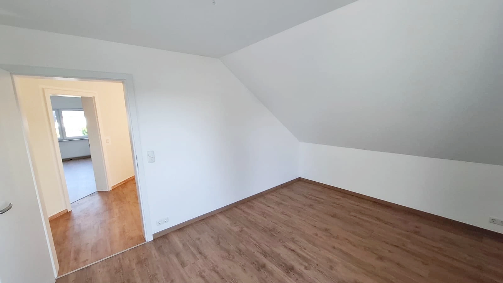 Dachzimmer mit hellen Wand- und Deckenflächen